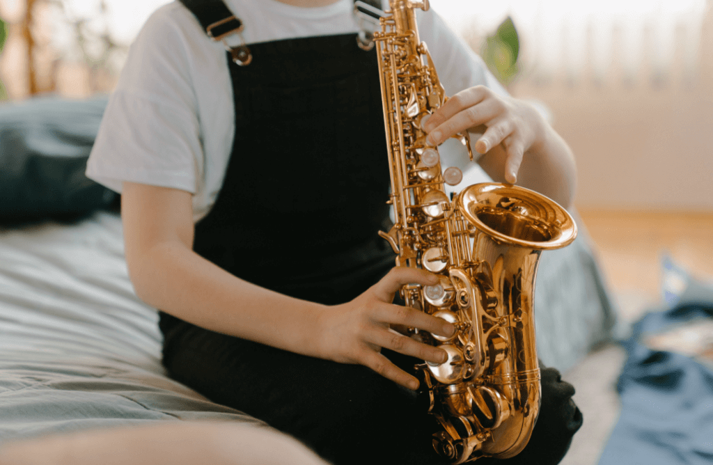 menino tocando saxofone após aprender com os melhores aplicativos parra aprender saxofone